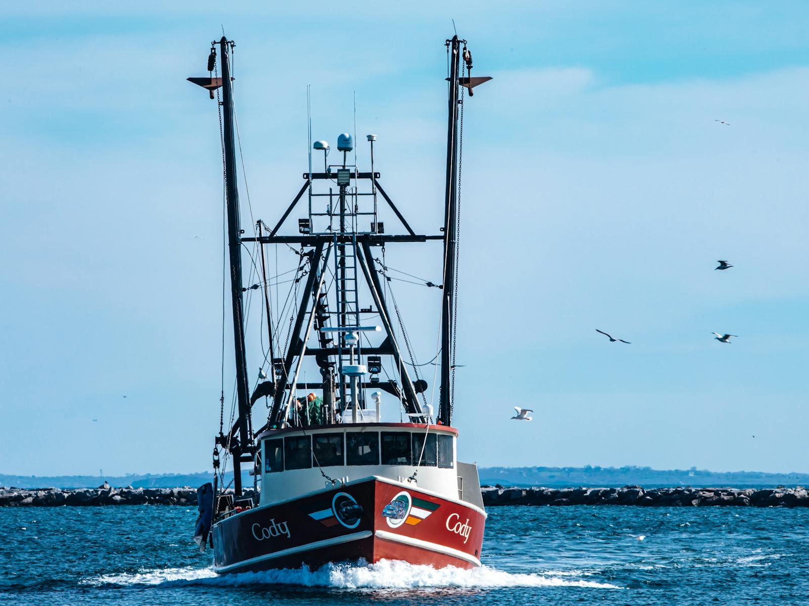 Fishing boat moving across Narragansett Bay with gulls overhead